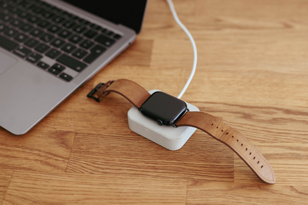 Apple Watch Ladestation aus Beton mit Uhr auf dem Schreibtisch neben einem Laptop